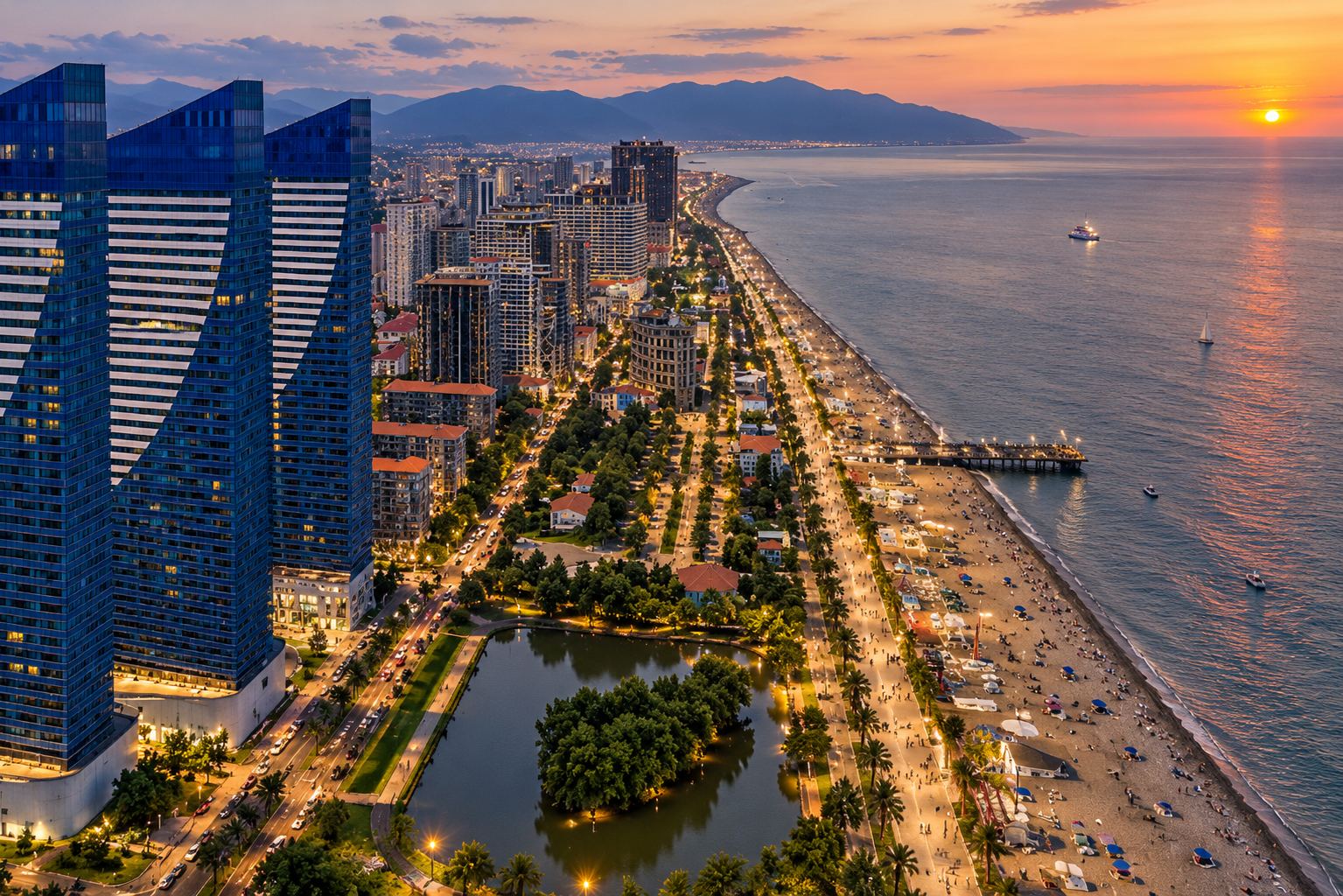 Синие высотные башни Orbi City на набережной Батуми вечером с подсветкой